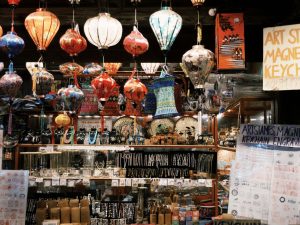 Colorful Asian market stall featuring traditional hanging lanterns and various crafts.